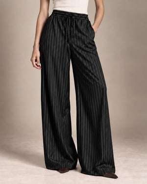 Close-up of the Bridget black pinstripe wide-leg trousers, showing the gathered drawstring waist and side pockets.