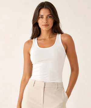 White longline tank top tucked into light tailored trousers, front view