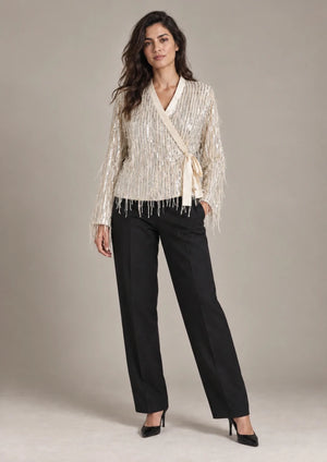 Full-length view of the Cassandra Panna fringe wrap jacket, styled with black cropped trousers.