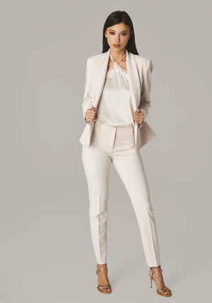 Plain ivory halter top layered under an ivory blazer