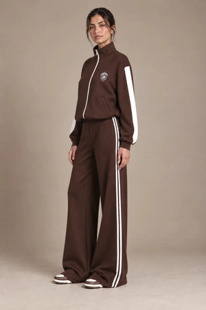 Angled view of Leila Moro zip track jacket and Mara wide-leg track pants with contrasting white stripes.