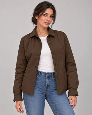 Front view of the dark brown Moro Mist Windbreaker Jacket worn open over a white top and jeans, showing the collar and snap fastenings.