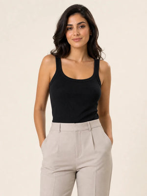 Black ribbed tank top tucked into light stone trousers, front view