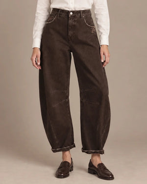 Front view of brown barrel-leg trousers showing panel seams, distressed details and turned-up hems.
