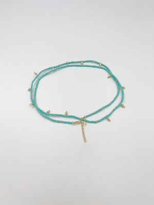 Beads necklace featuring 18 karat gold plated ornaments that can be styled as a bracelet or belt. - ELLY