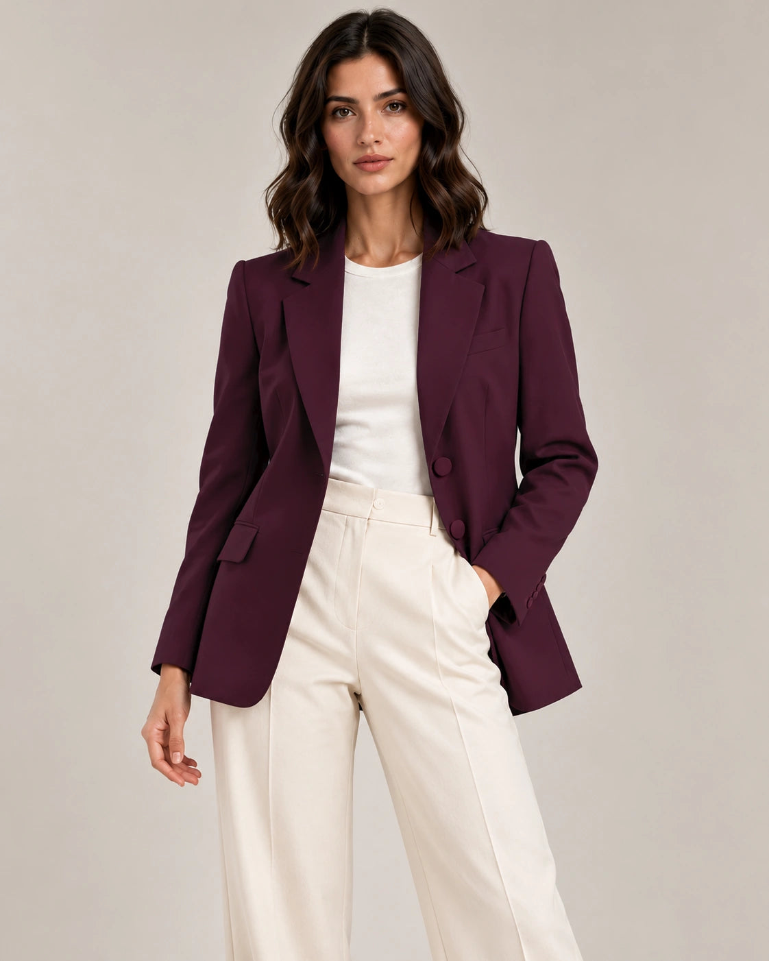 Front styling view of the Adelaide Bordeaux tailored blazer with notched lapels and flap pockets, worn open over an ivory top and trousers.