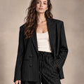 Close-up of the Alba black pinstripe double-breasted blazer with notched lapels, styled with matching trousers.