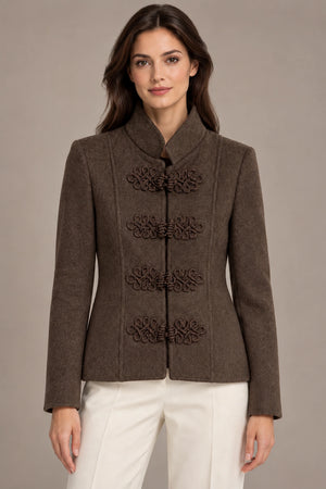 Front view of the brown Allegra Moro Toggle Jacket with a stand collar and decorative frog closures, worn with ivory trousers.