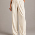 Front detail of the ivory Amata Panna wide-leg trousers showing fine gold-coloured vertical pinstripes and front pleats.