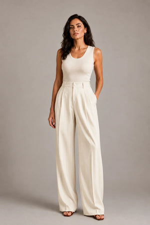 Full-length front view of the ivory Amata Panna wide-leg trousers with fine gold-coloured pinstripes, styled with an ivory sleeveless top.