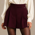 Close-up of Anima Bordeaux tailored skort showing the high waistband and front pleats.