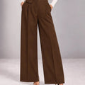 Front detail of the brown Arianna Tabacco wide-leg trousers, showing the button waistband, front pleats and small buttoned flap.