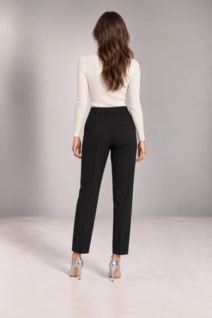 Full-length back view of black Bianca tailored trousers showing the gathered back waistband and ankle-length legs.