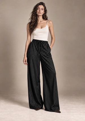 Full-length view of the Bridget black pinstripe wide-leg trousers styled with an ivory camisole.