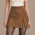 Camelia Asymmetric Mini Skirt in camel brown, close-up front view showing the asymmetric wrap-effect panel and side slit