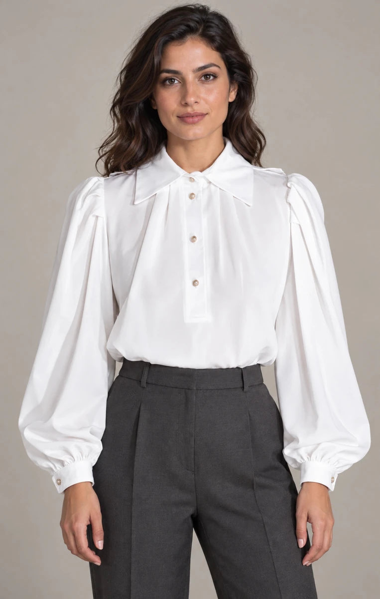 Front view of Camicia Plissé Bianco white puff-sleeve blouse with the collar buttoned, worn with grey trousers