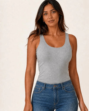 Grey longline tank top styled with blue jeans, three-quarter front view