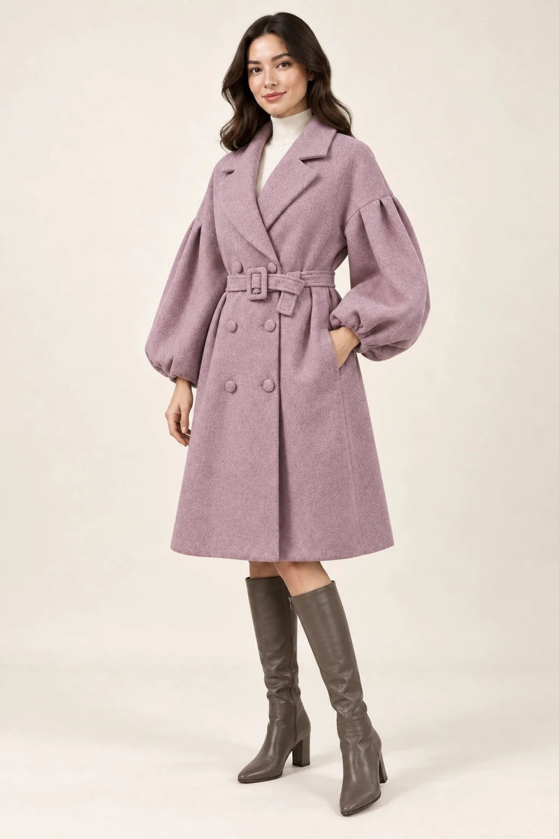 Three-quarter view of Cappotto Rosa Melange, a dusty pink belted coat with puff sleeves, with the model's hand in a side pocket.