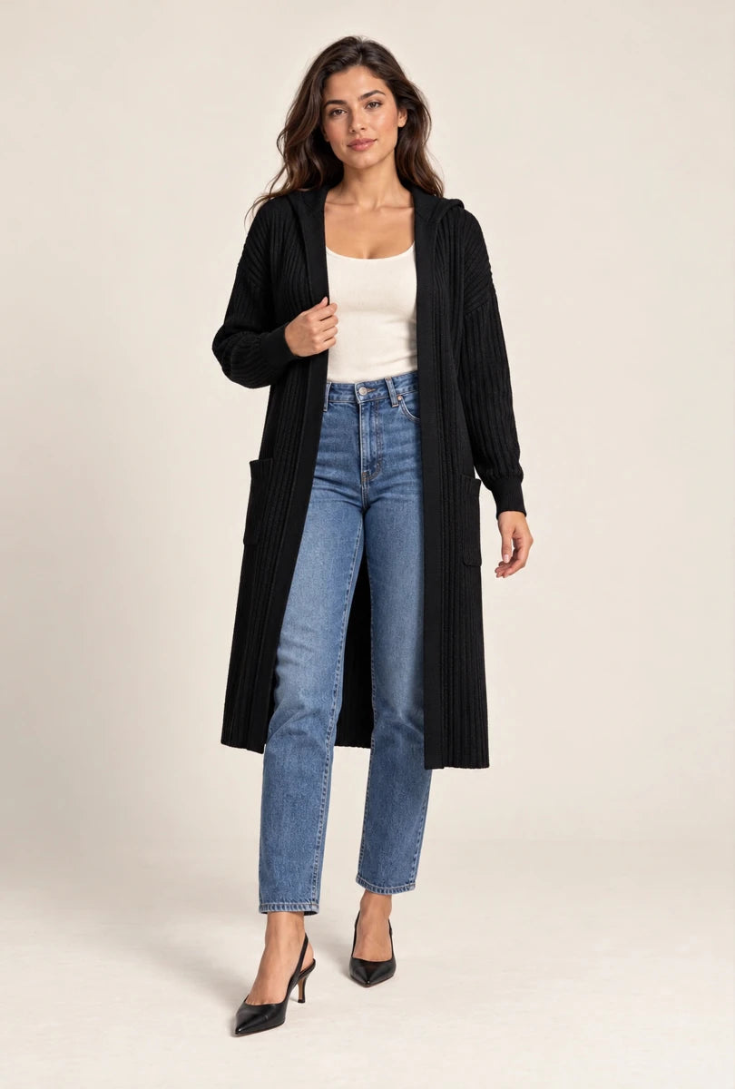 Model wearing ELLY's long black ribbed hooded cardigan with patch pockets, a white top and blue jeans, full-length view.