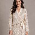 Close-up of the Cassandra Panna fringe wrap jacket with a side tie, worn with the matching Consuelo sequin skirt.