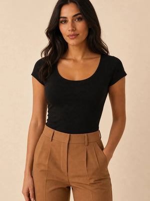 Black scoop-neck cap-sleeve top tucked into camel trousers, front view