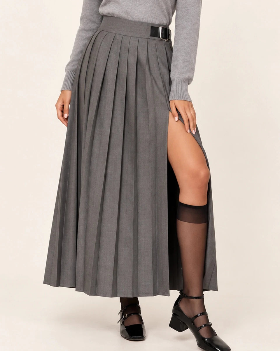Close-up of ELLY Eleganza Skirt in Grigio showing grey pleats, a black waist buckle and the slit with one knee bent.