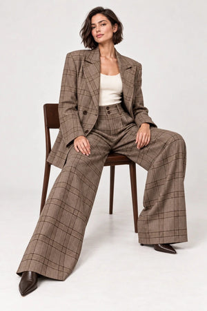 Rosalinda brown check blazer and matching Hope wide-leg trousers shown seated, styled with an ivory sleeveless top.