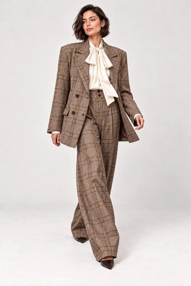 Rosalinda brown check blazer and matching Hope wide-leg trousers shown walking, styled with an ivory bow-neck blouse.