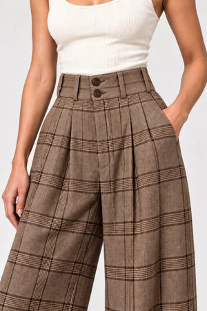 Close-up of Hope brown check trousers showing the high waistband, two front buttons, belt loops and pleats.