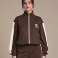Close-up of Leila Moro track jacket showing the high collar, front zip, white sleeve stripes and chest badge.