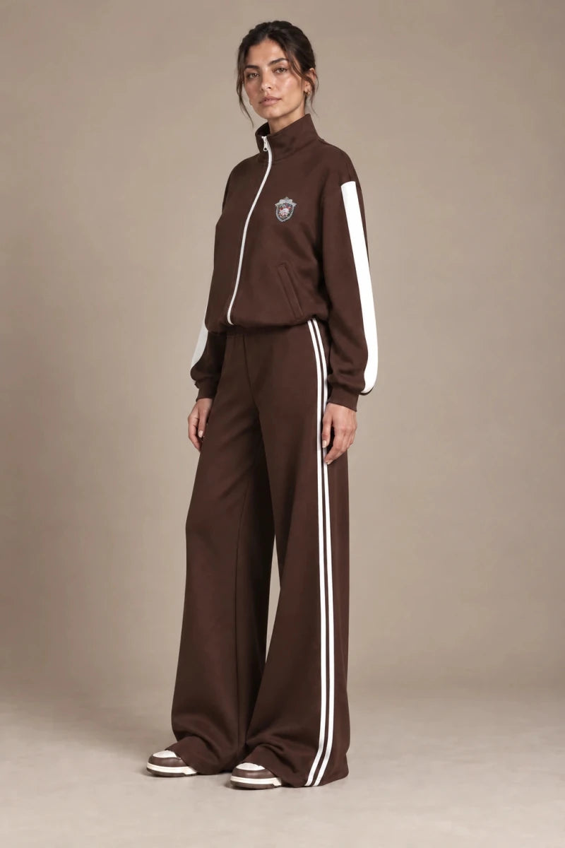 Angled view of Leila Moro zip track jacket and Mara wide-leg track pants with contrasting white stripes.