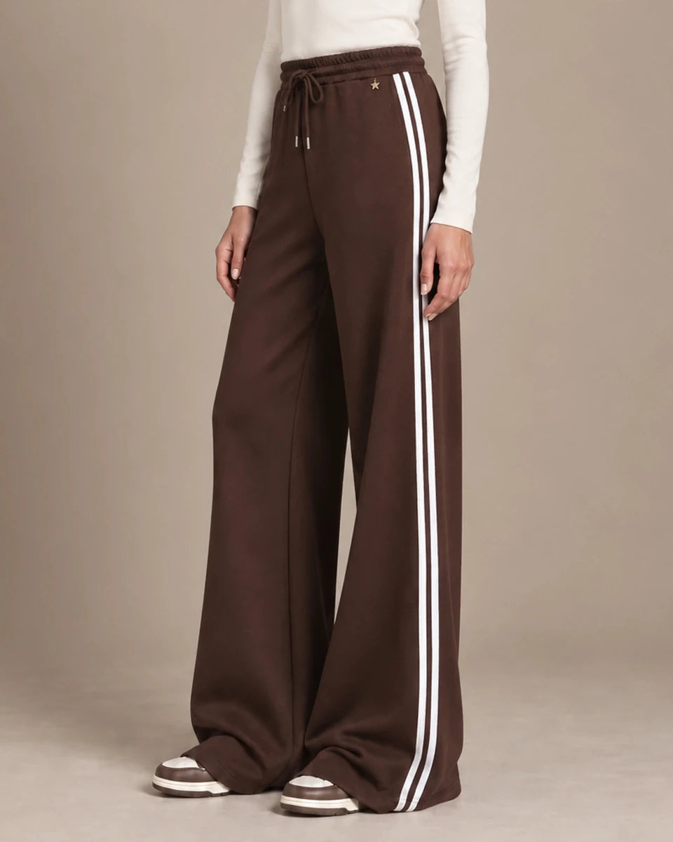Mara Moro wide-leg track pants showing the drawstring waistband, small star detail and paired white side stripes.