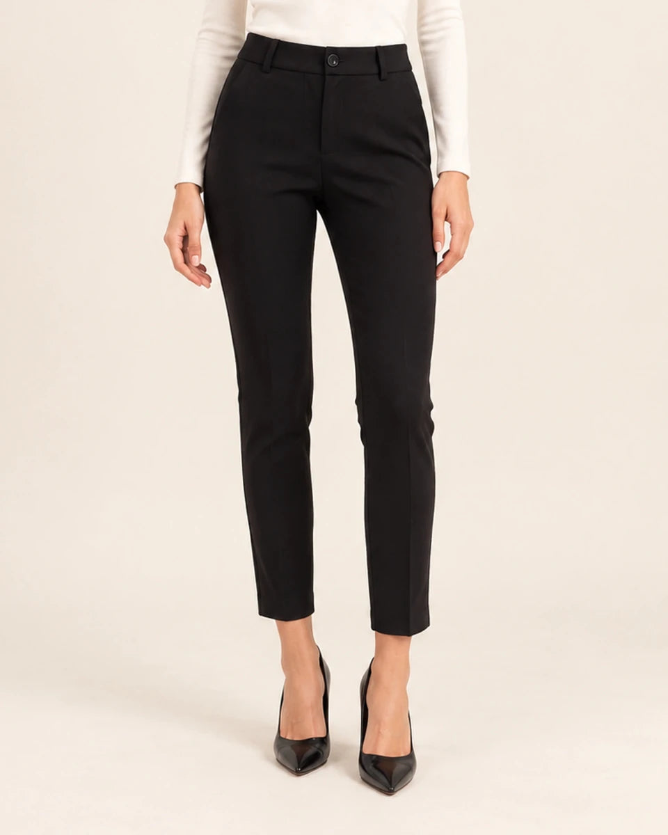 Front detail of black tailored ankle-length trousers showing the waistband and tapered legs, with arms at the sides.