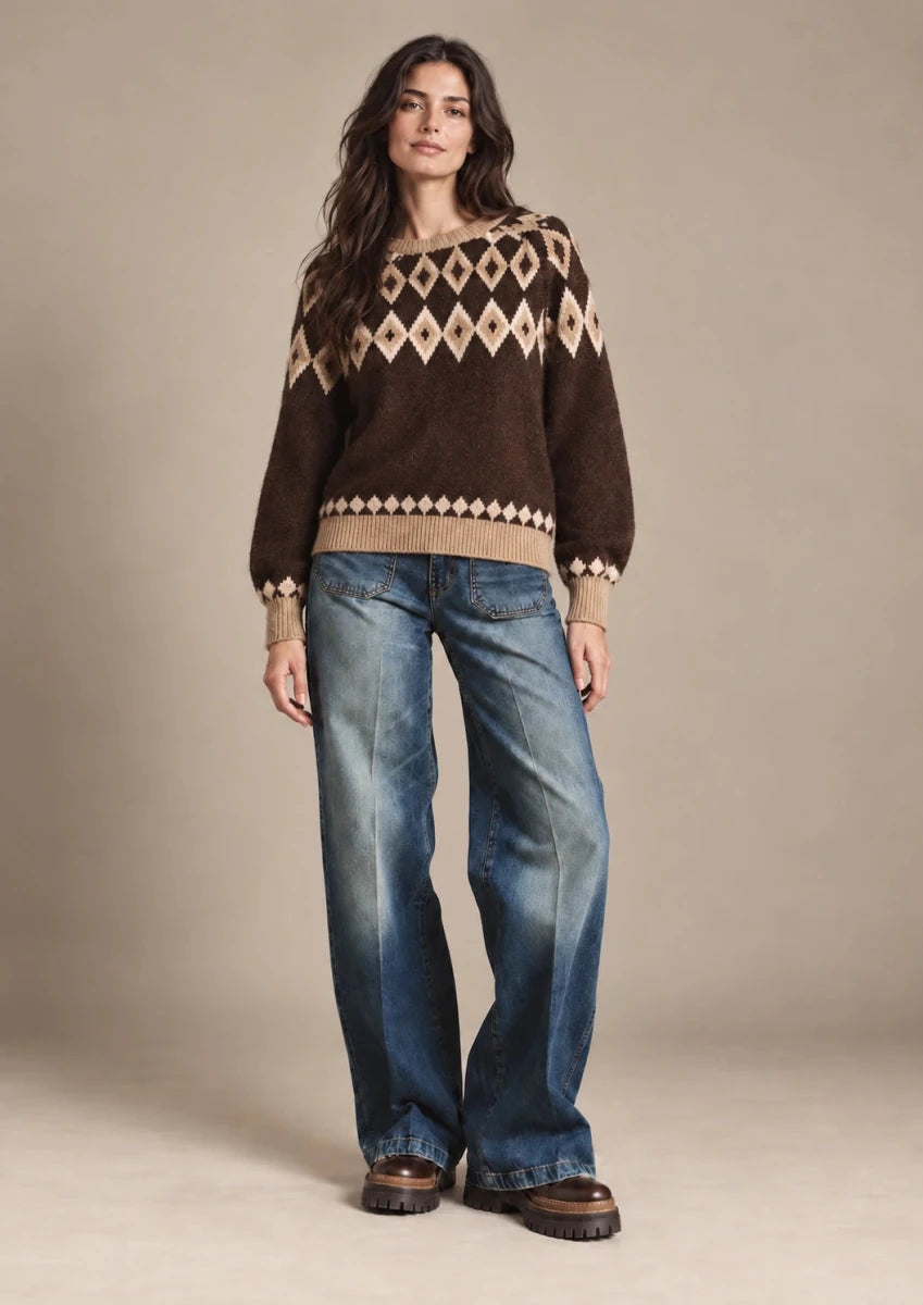 Full-length front view of Odessa brown diamond-knit sweater worn untucked over blue jeans.
