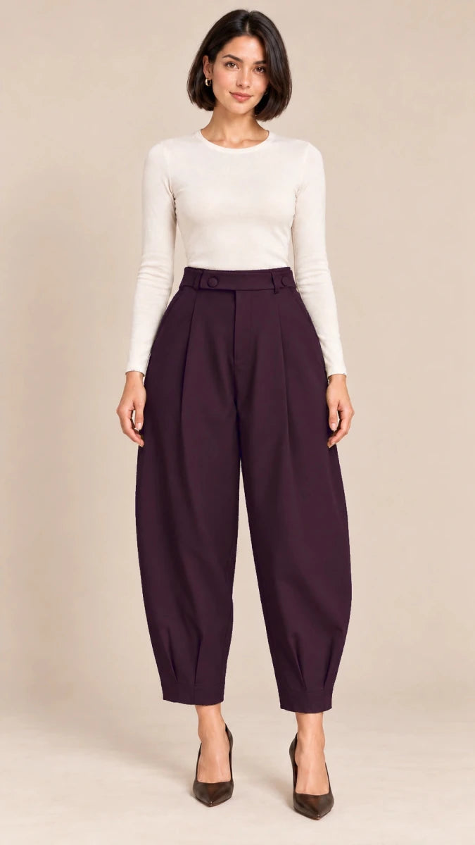 Full-length front view of deep plum Queen barrel-leg trousers with a button-detail waistband and pleated ankle hems, worn with an ivory top.