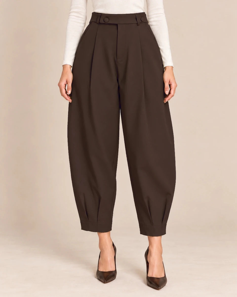 Front detail of deep brown Queen barrel-leg trousers showing the button-detail waistband, front pleats and pleated ankle hems.