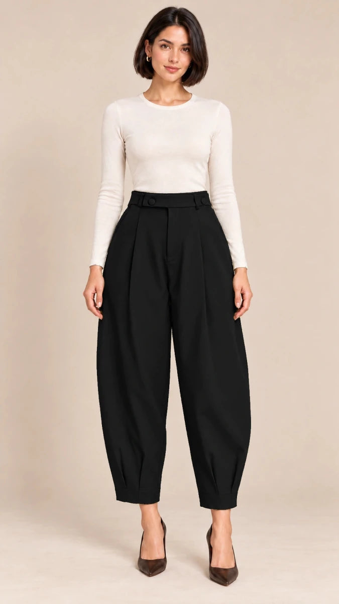 Full-length front view of black Queen barrel-leg trousers with a button-detail waistband and pleated ankle hems, worn with an ivory top.