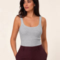 Grey ribbed tank top tucked into burgundy trousers, three-quarter front view