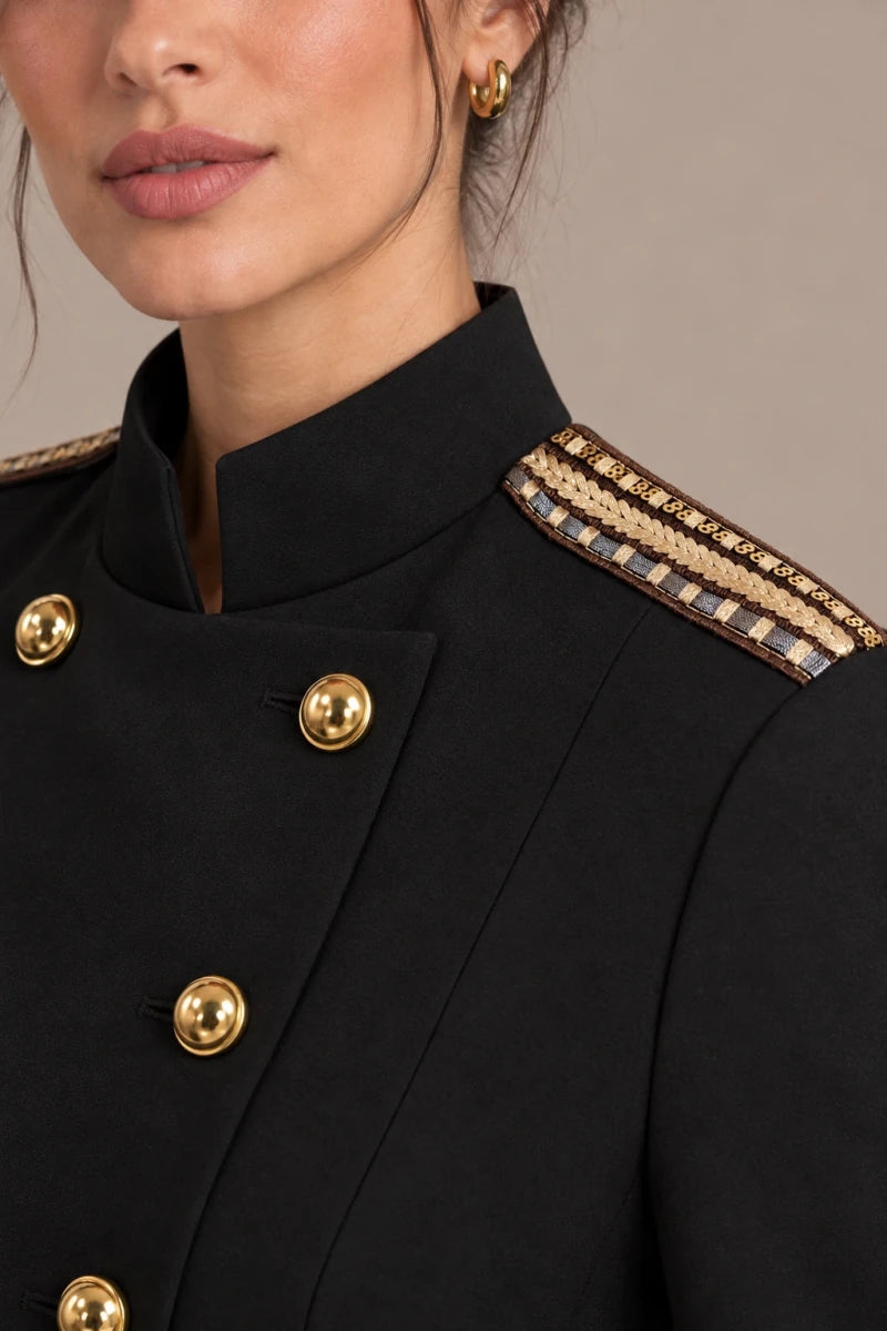 Close-up of the black blazer's stand collar, gold-tone buttons and decorative shoulder trim.