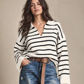 Close-up of the Rossana knit sweater with black horizontal stripes on a cream base and an open polo-style collar.