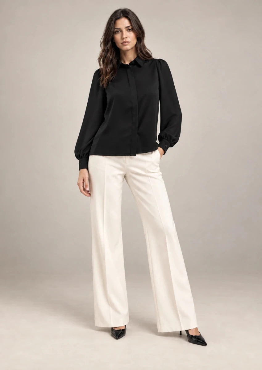 Full-length styling view of the black Serena shirt with a pointed collar and long puff sleeves.