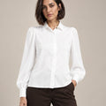 Close-up of the white Serena shirt with a pointed collar, gathered shoulders, long puff sleeves and a concealed front placket.