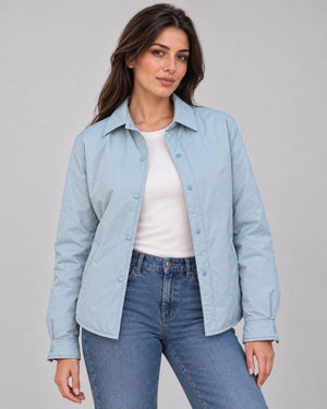 Front view of the pale blue Sky Mist Windbreaker Jacket worn open over a white top and jeans, showing the collar and snap fastenings.