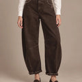 Front view of brown barrel-leg trousers showing panel seams, distressed details and turned-up hems.