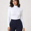 White stretch-cotton mock-neck long-sleeve top styled with navy trousers, front view