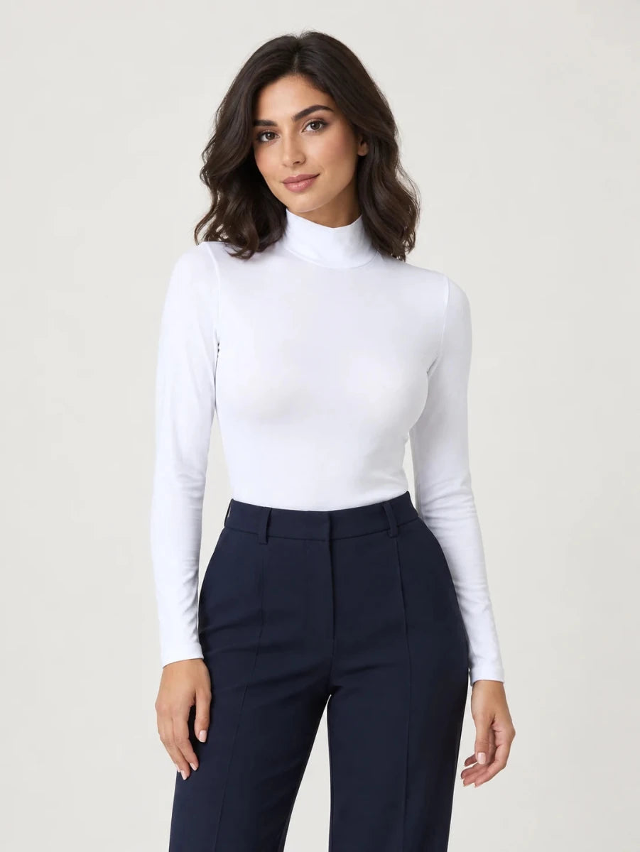 White stretch-cotton mock-neck long-sleeve top styled with navy trousers, front view