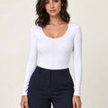 White stretch-cotton scoop-neck long-sleeve bodysuit styled with navy trousers, front view