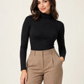 Black stretch-cotton turtleneck long-sleeve top styled with camel trousers, front view