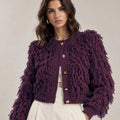 Close-up of the Viola cardigan showing its fringe-textured surface, round neckline, gold-tone buttons and ribbed cuffs.