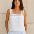 Model wearing the ELLY white floral eyelet lace camisole top with square neckline and scalloped hem.